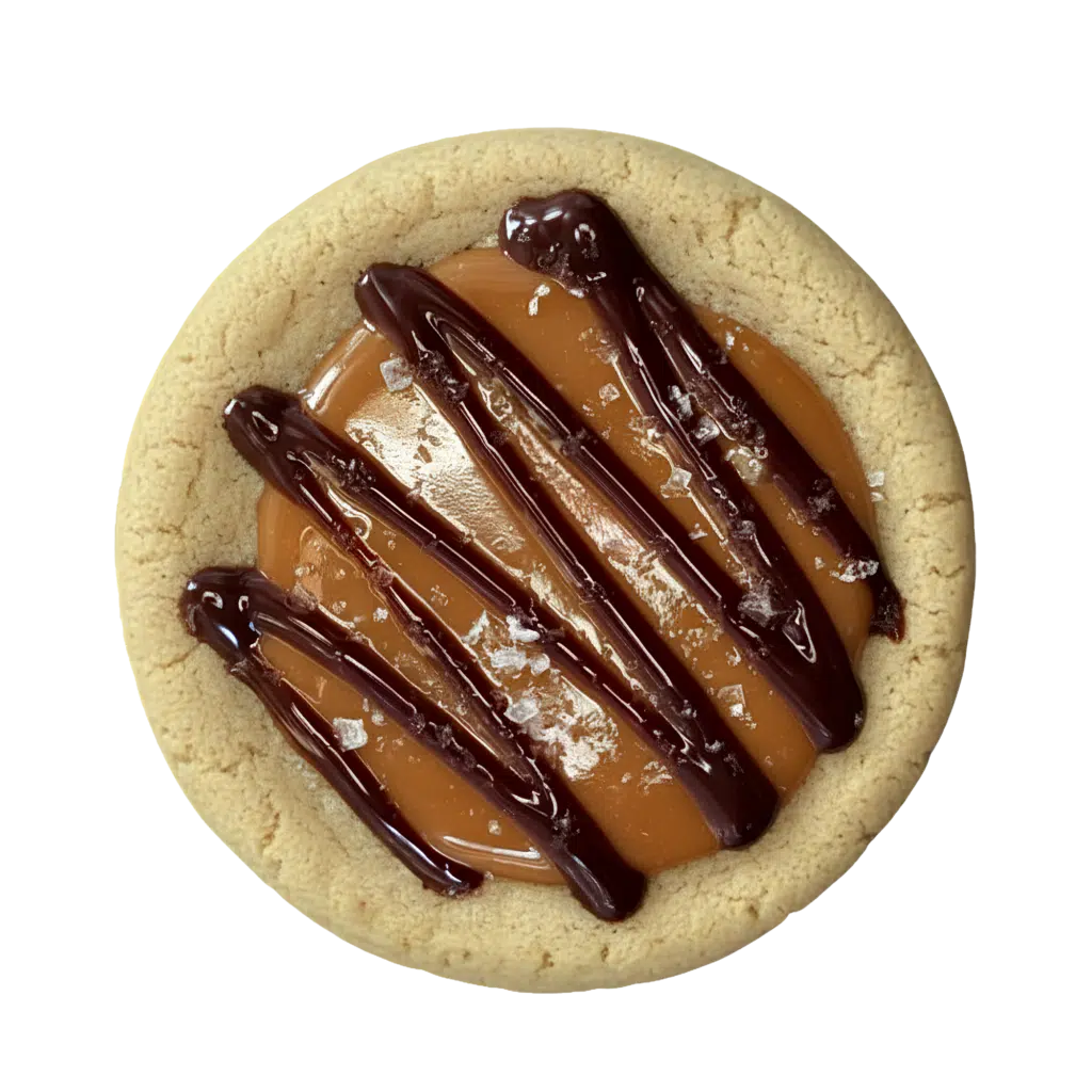 A round, rich brown butter gluten free cookie topped with a layer of smooth caramel, drizzled with dark chocolate, and finished with a sprinkle of flaky sea salt.